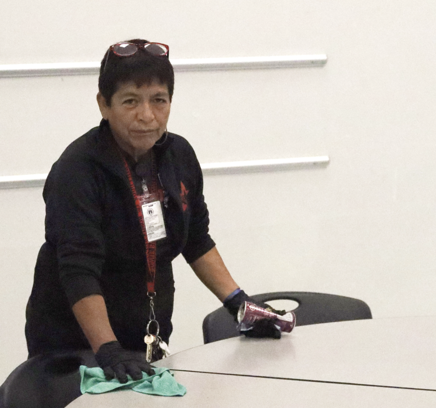 CAFETERIA WIPE DOWN: Custodian Emily Leal sanitizes a cafeteria table. A custodian at Bowie is responsible for tasks such as  sanitizing in between lunches. 