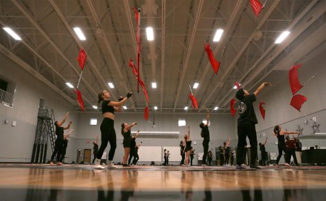 THE TOSS IS UP: Winter guard members practice their new choreography during sixth period. The group had a guest choreographer come in and teach them the piece that they will be performing all season.