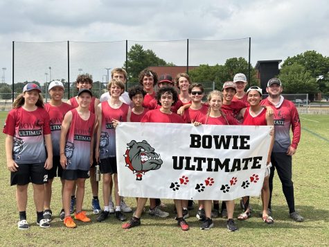 At the end of the tournament, the entirety of Bowie’s Ultimate Frisbee Team poses for a photo, holding up a banner that says “Bowie Ultimate”.