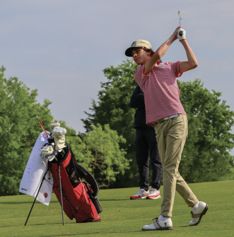 FOLLOWING THROUGH: Sophomore Knox Cannon aims for the green with an iron shot. In his second appearance, Cannon successfully competed in the district tournament.