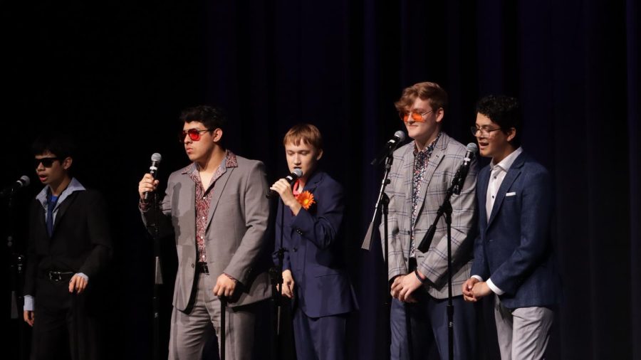 SUNGLASSES AND SUITS: Junior Jason Bulnes (far left), junior Joab Astran (left), freshman Quint Cheshire (center), senior Liam McLemore (right), and junior Marcelo Canepa (far right) perform the song “Peg” by Steely Dan at the cabaret show. The show consists of numerous theatrical music performances from the entire choir program