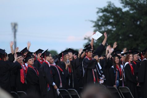 CAPS ON:  With their hands in the air, the graduating seniors gather together during the ceremony to celebrate the completion of their high school education. This year, the graduation was held at Burger Stadium. 