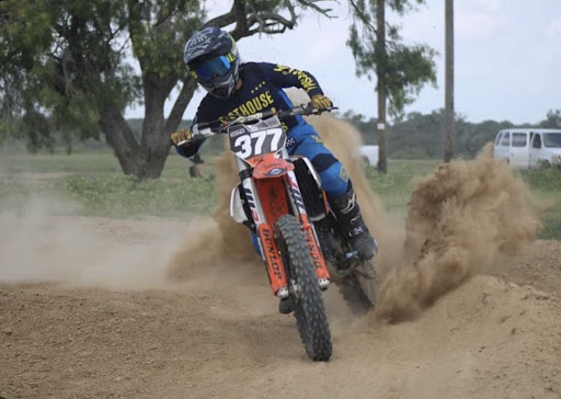FLYING THROUGH: Joanna Tebbs rides around a dirt course, showing off her riding skills and orange motorbike. Tebbs has done motorbiking since 2019.