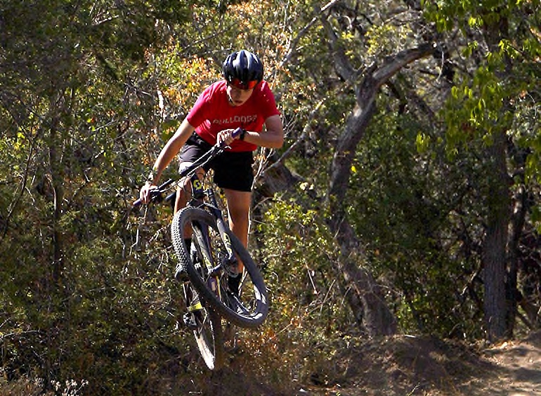 SPEED AND STYLE: Baker turns his wheel and whips his tail at the Slaughter Creek greenbelt, where the many trails offer a large range of challenges for mountain bikers in the form of rocky terrain, big jumps, and alternate routes that vary greatly in speed. Baker has been riding these trails ever since he started biking and knows them like the back of his hand. “I love that I get to hang out with my friends and we can go on long rides around the neighborhood and around Austin, both on the road and on trails,” Baker said. 