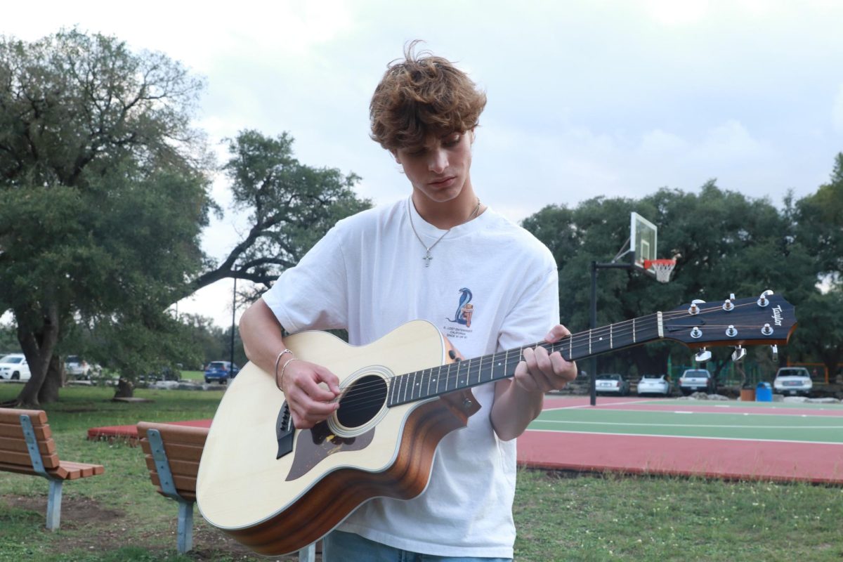 STRUMMING AWAY: Junior Knox Cannon poses while playing his guitar outside. Cannon has recently ramped up a large fan-base on TikTok, acquiring over 150 thousand followers. 