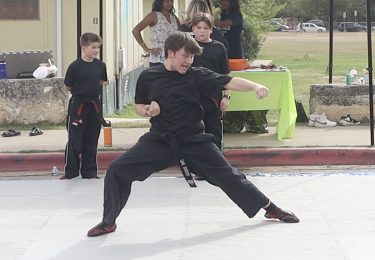 Junior Luke Johnson demonstrates his taekwondo skills for younger students.
