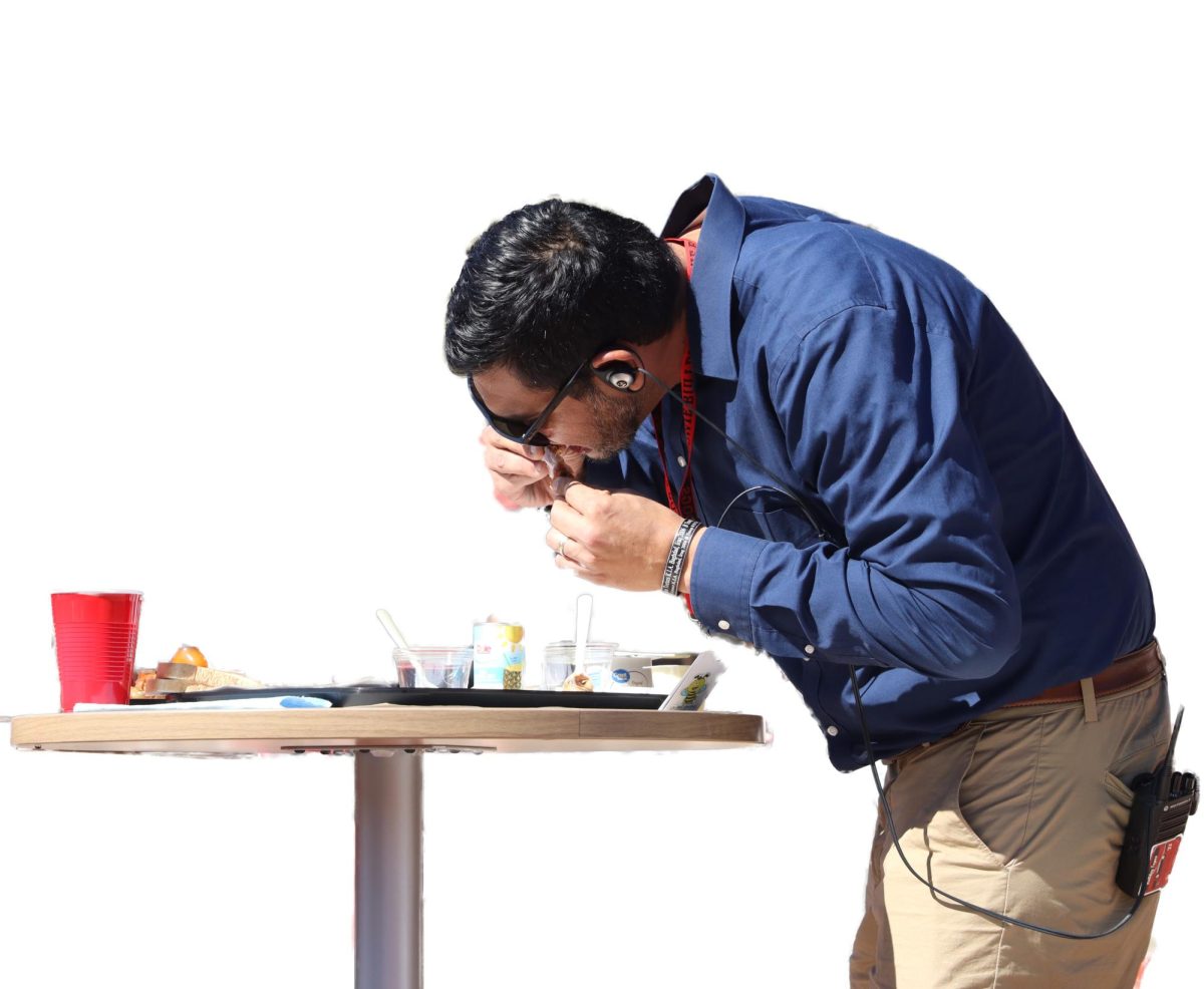 HOT ONES: Assistant Principal Hector Munoz bites into a hot chicken wing during a Business Professionals of America fund raiser. Hot Ones was a fund raiser put on by BPA to raise funds for travel and competition expenses for the year.