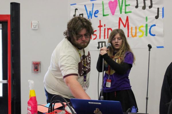 ALL EYES ON THE MUSIC: Choir teacher Aaron Bourgeois assists student with choir-led karaoke booth. 