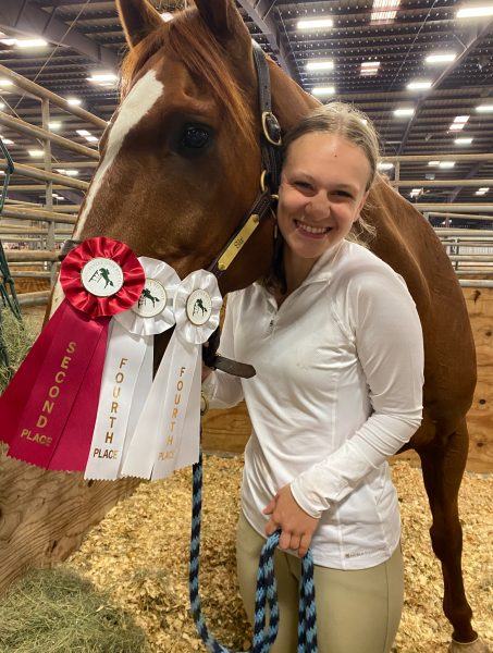 WINNING RIBBONS: Sophomore Emily Sturzl shows off her ribbons after a competition, winning second place in one of her events and fourth in two others. Sturzl plans to continue show jumping with her horse Sir through the current season. 
PHOTO COURTESY OF Emily Sturzl