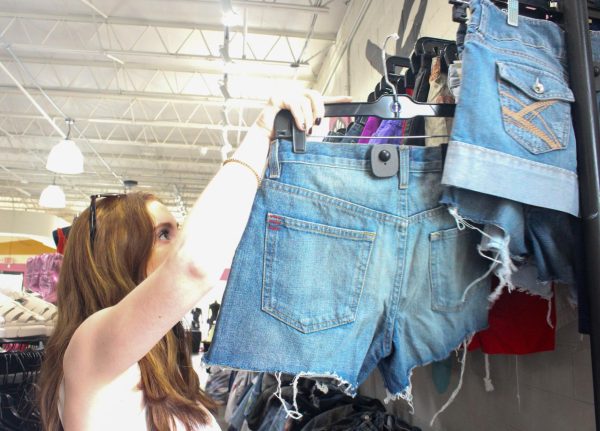 PICKING OUT DENIM: Katelyn Dillard looks at a pair of jean shorts in the denim section at Pavement. Pavement buys and sells a lot of denim in all different styles, colors, and sizes to appeal to all kinds of shoppers. “I like the fact that there’s a lot of variety in denim and different brands,” Dillard said. “They just have a really good selection of jeans and other denim styles.”
