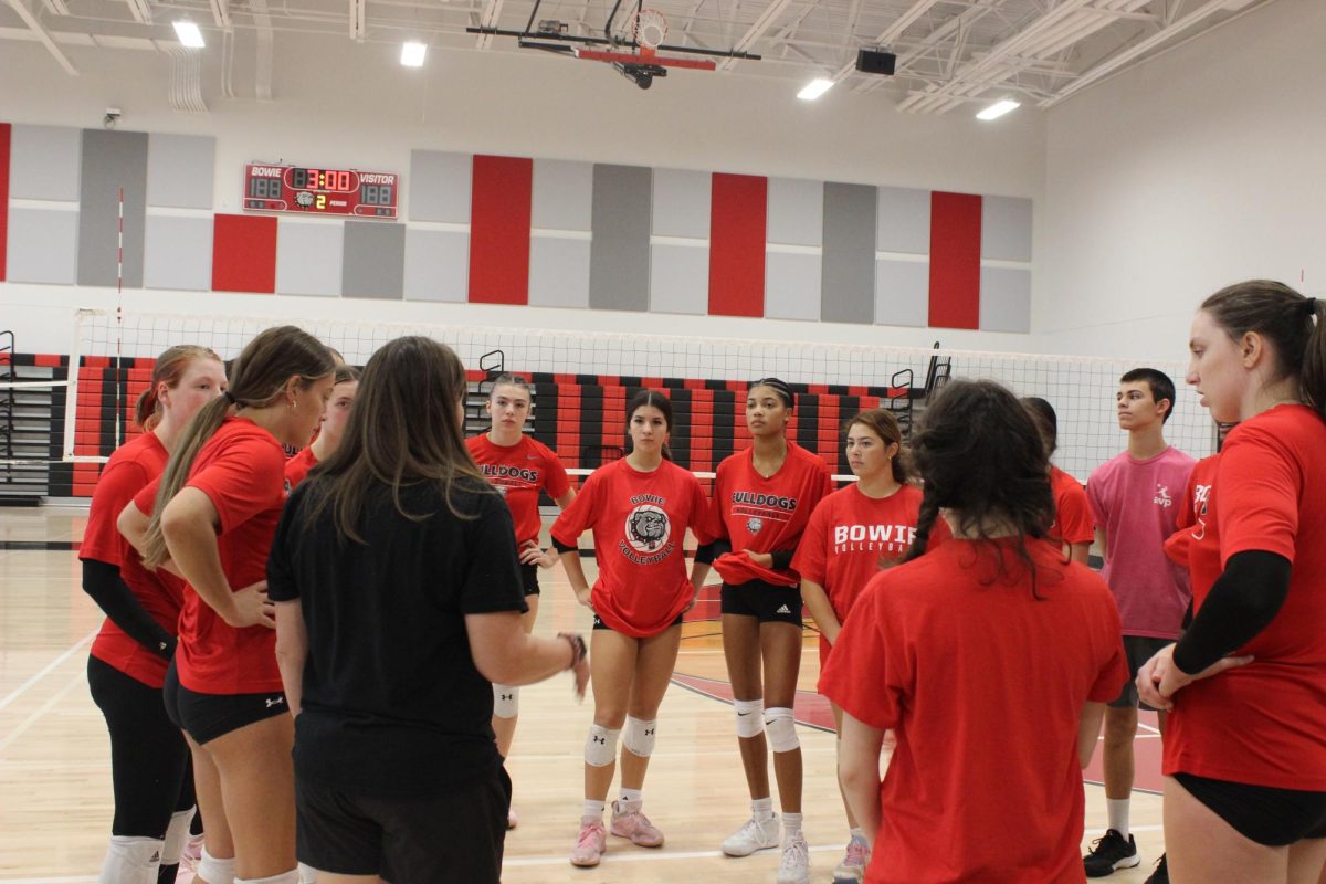 In a huddle, the Varsity volleyball team gets notes on their practice.