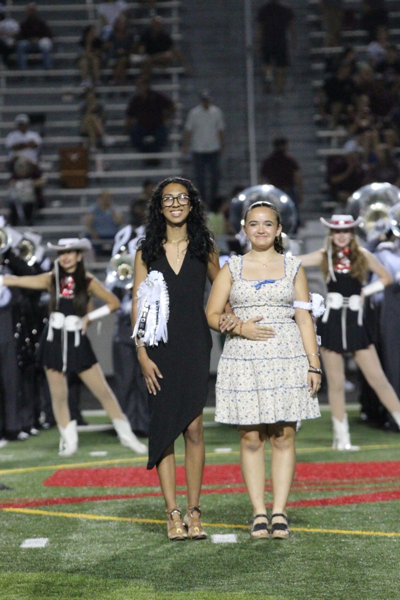 ON THE FIELD: Making it to the final six, senior Bubba Infante, escorted by Besa Carney, took his place on the field at halftime with the rest of the homecoming court. 