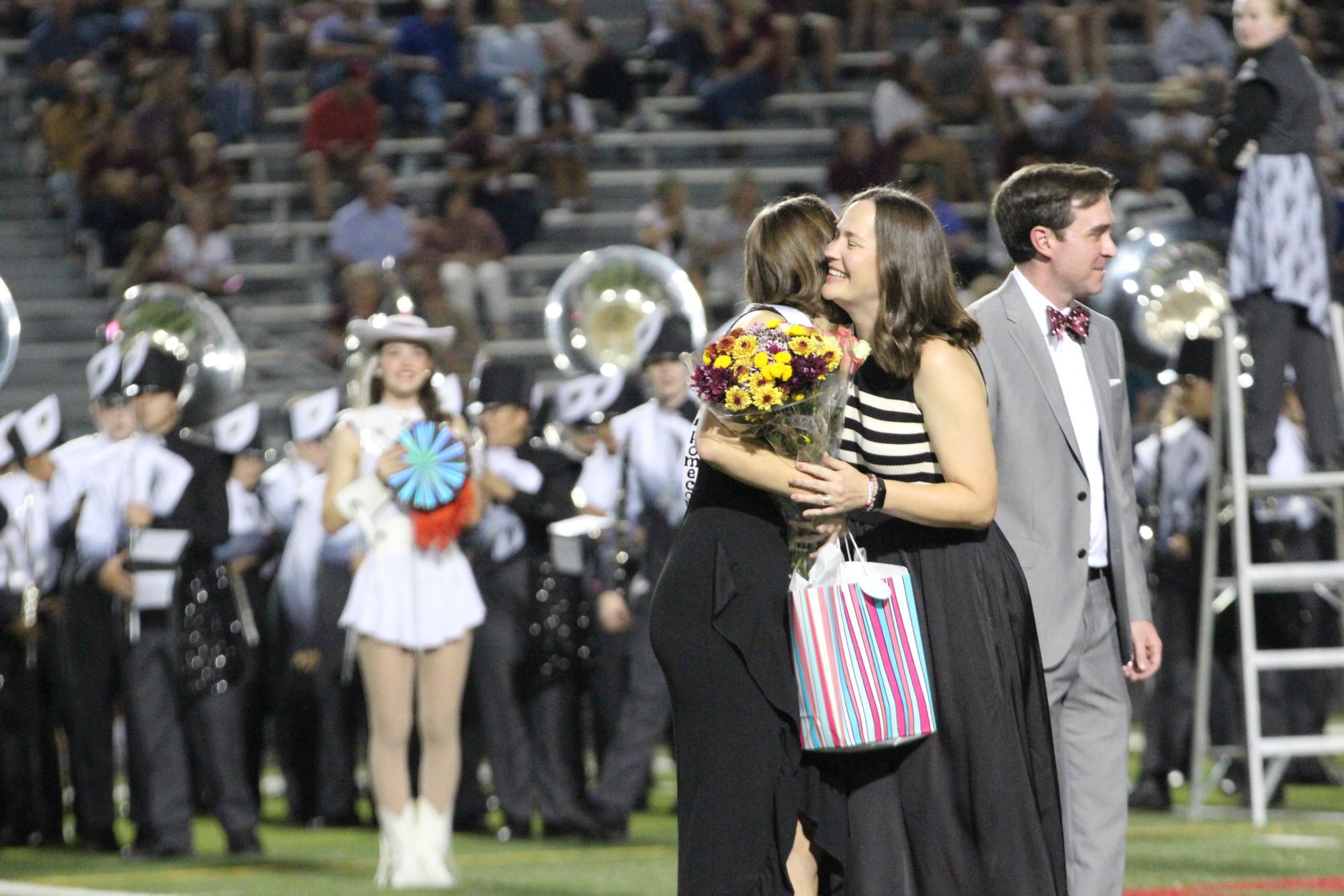 CELEBRATING ROYALTY: Teacher Kelly Langdon hugs senior Kate Bookidis congratulating her on winning homecoming royalty. As a class of 2025 sponsor, Langdon brings flowers and sashes to the homecoming royalty elects. “Some seniors were almost campaigning to be nominated, which I thought was really interesting,” Langdon said. “I didn’t know that people did that.