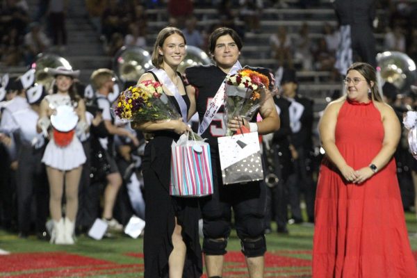 SENIOR ROYALTY: Seniors Kate Bookidis and Clayton Migl take the field as Homecoming Royalty at the Homecoming game. Bookidis and Migl did not know they won until the end of the homecoming court ceremony. “We are both very excited to win this title because we had hoped to win, although I wouldn’t have been very disappointed if we didn’t win,” Bookidis said. “The experience was very fun, and I’m glad I got the chance to do it no matter how it turned out.”