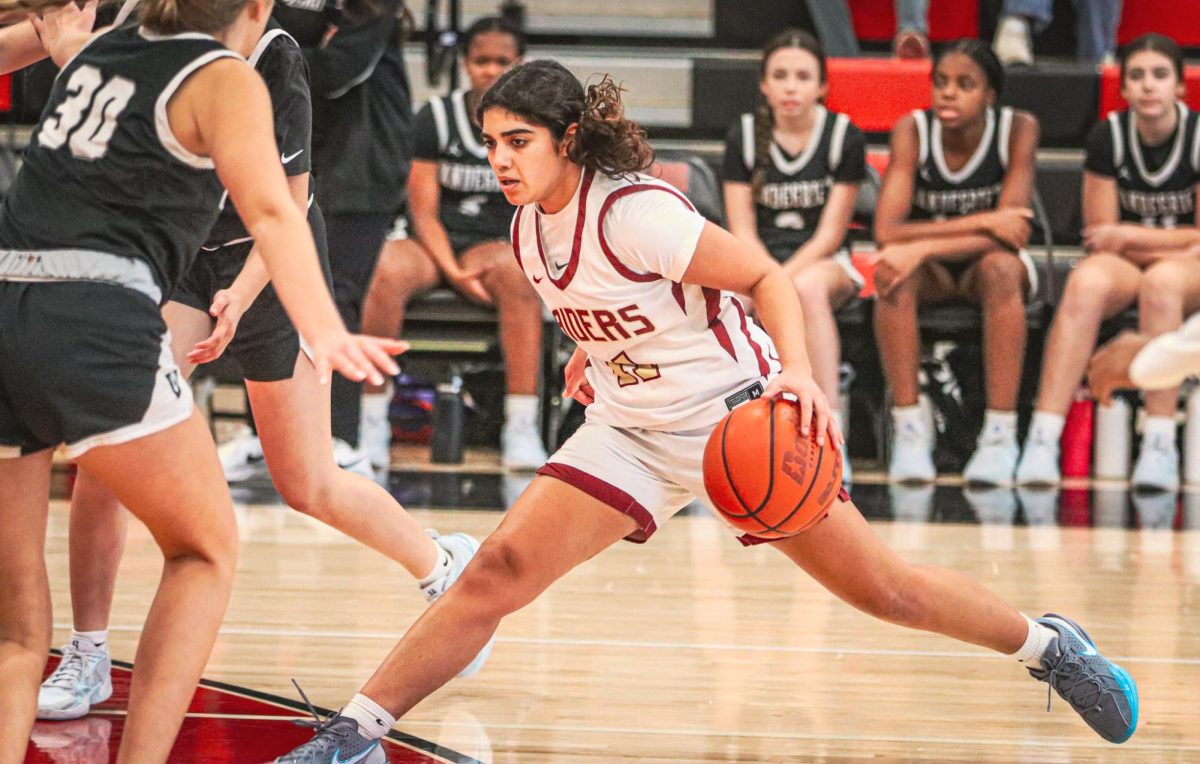 Straddling the line, the Rider's point guard lunges past a defender during Bowie's non-varsity tournament this week. 