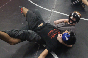 LOCKED DOWN: Junior Jesse Sheets holds Nikhil Chaku down on the mat. Sheets recently broke his nose resulting in him having to wear protective masks during practices and tournaments.