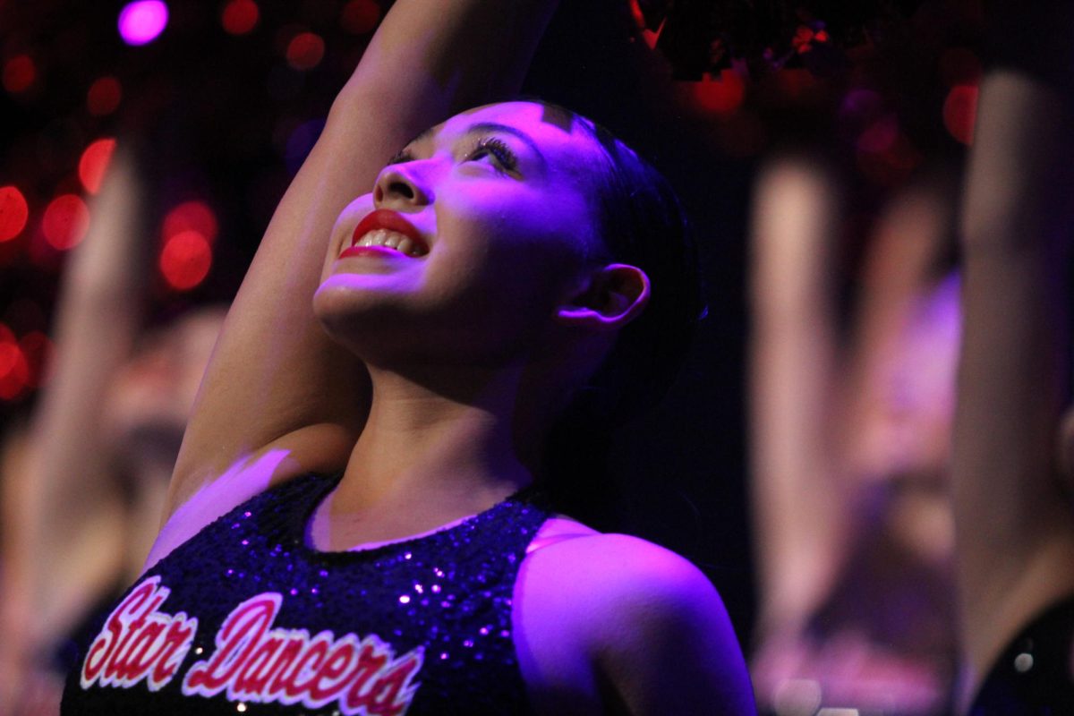 During the Star Dancer's performance, girls strike intense poses with broad smiles. 