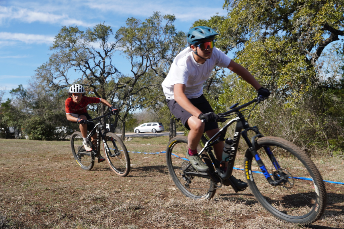 PEDAL TO THE METAL: Daniel Morgali races past another bicyclist during a trail ride, a pair of RideLens set upon his face. Morgali created RideLens in the hopes of making high quality, but cheap, sport-glasses. 