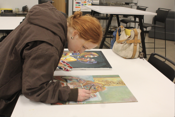 ACRYLICS APPEAR: Bristle by bristle junior Amelie Baker carefully puts the last drops of acrylic paint on her VASE submission. Baker's art pieces are inspired by the joy in her friends. 