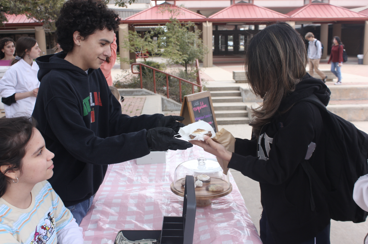 PERFECT PASTRIES: Zachary Pasley gives a customer a freshly made Neapolitan cookie. Culinary students sold four different pastries for $3 each at the event.