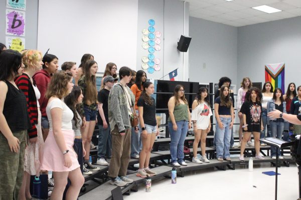 RHYTHM RISES: Varsity choir practicing songs to prepare for state competitions and ensemble. Choir director Aaron Bourgeois conducts his students as they sing.