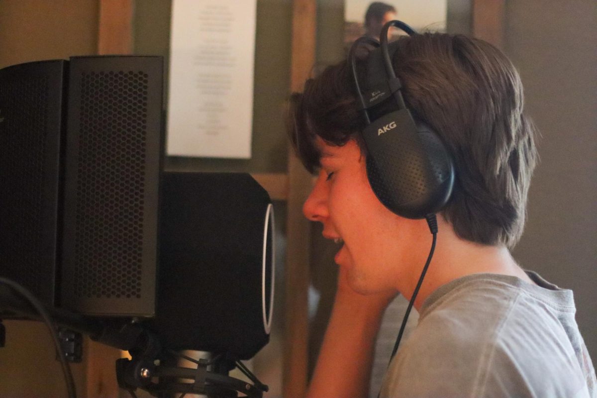 IN STUDIO: Junior Nick Forrest sings in his office using his microphone. Forrest’s music is currently only streaming on SoundCloud but he does plan on moving to Spotify eventually.
