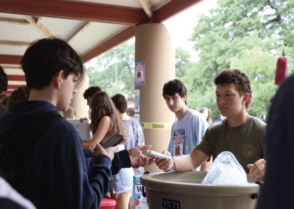 COLD CAMPAIGNING: Student Council co-president elect Reed Watts exchanges an ice cream sandwich for a vote. Watts watched as students selected his name on their ballot and submitted their choice to ensure he would get a vote, and voters would get a sandwich. 