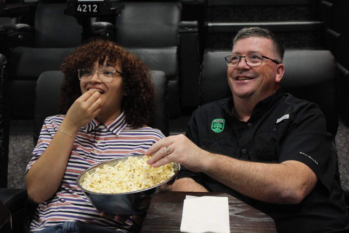 POPCORN AND MOVIES : Zoriyah Wells and another fellow movie enthuesntist enjoy commplemantary popcorn while watching Alamos Drafthouse specialty ad’s before the movie showing. Once the light fully dimed they experience the new Marval Studios films, Thunderbolts*.