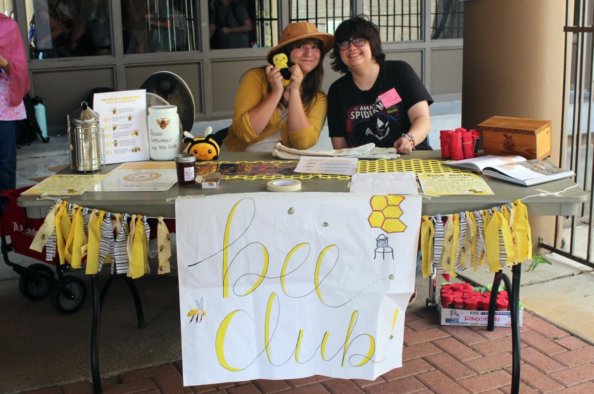 JOIN THE BEE HIVE: Seniors Blake Ferguson and Emily LeJeune pose together at the Bee Club booth. LeJeune and Ferguson  handed out honey and provided information about the Bee Club to students that stopped by at Club Fair. “I liked representing the Bee Club at Club Fair,” LeJeune said. “Seeing people’s excitement and wonder about Bee Club made me really happy.” 