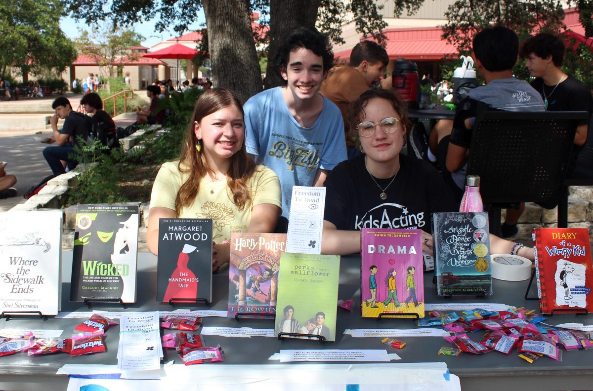 BOOKS WITHOUT BORDERS: Seniors Riley Soffera, Jack Lowe, and CJ Pelt show off the books at their Freedom to Read club booth. The Freedom to Read club has meetings for members to come together to discuss books that have been banned from public or school libraries. “We had books on little stands so that people could easily see them and we had a sign that said information about our club and the title of our club,” Soffera said. “We had a lot of kids that were looking at the books and asking about our club, and we even got some new members today.”