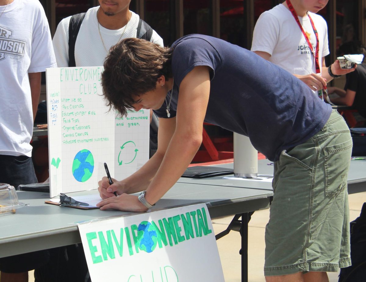 YOUR NEXT ADVENTURE STARTS HERE: Junior Sebastion Pelz signs up for the Environmental Club. Pelz viewed Club Fair as an opportunity to explore new possibilities and signed up for clubs that aligned with his interests. “I was honestly quite impressed by all the clubs at Club Fair,” Pelz said. “The club that caught my attention the most was BPA (Business Professionals of America) because I’m interested in business, and I thought it was really cool to see a booth that matched one of my interests.”