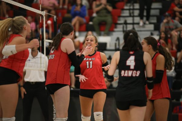 CELEBRATING THE W: Senior Clara Morgan celebrates with her team after scoring yet another point for the womens volleyball team. The Lady ‘Dawgs are striving for a successful playoff run.