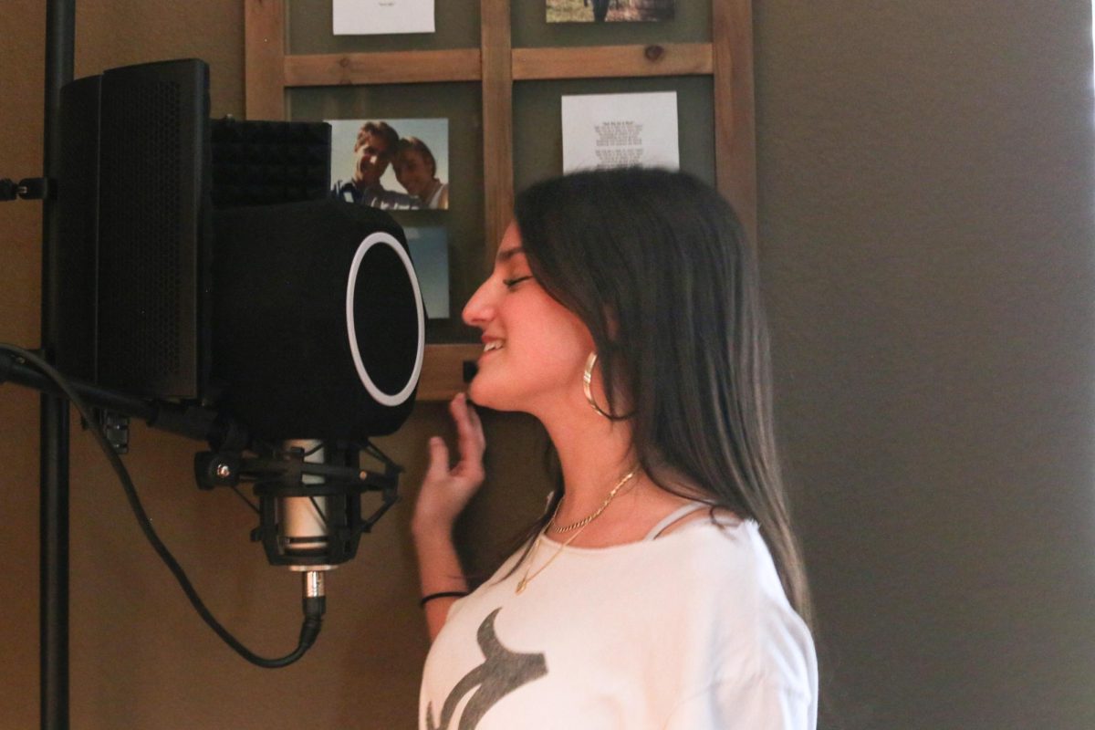 LETTING GO: Ava Clark sings into a studio microphone.  Clark stated that music is her way of processing emotions, and recording her song in a studio was life changing.