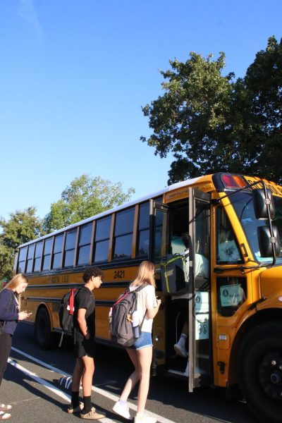 ALL ABOARD: Due to bus issues as of recent, students are seen boarding the bus to school upwards of 10 minutes late. Students are hoping they will be granted a spot as overcrowding has led people to be stranded. 