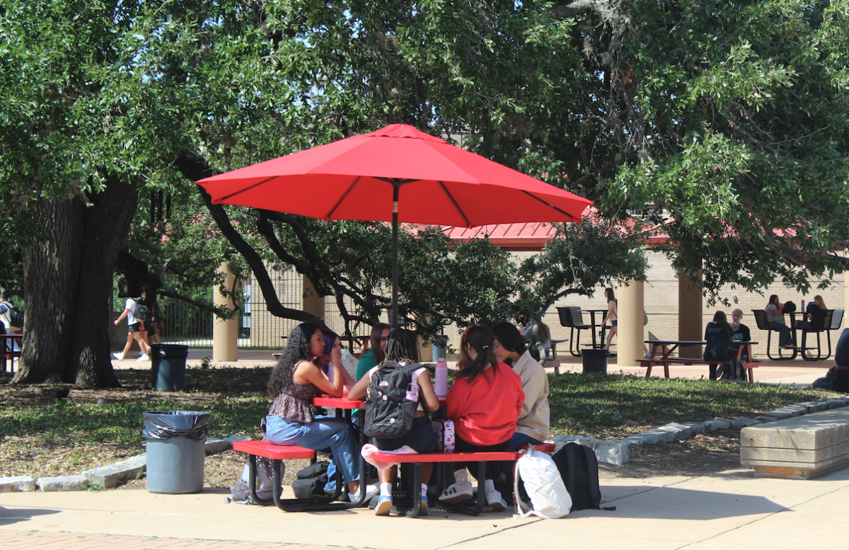 SHADED FROM SUNSHINE: Students sit together during their lunch under umbrellas in the courtyard, keeping them out of the harsh sun. These umbrellas were put up over summer to provide shade for tables in the courtyard.