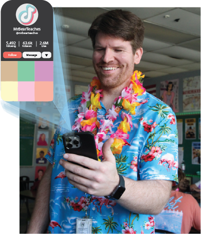 CHEESING FOR THE CAMERA: Chris Simons smiles down at his phone, just as he greets the teaching focused TikToks he makes.  Simons’ TikTok content varies from “day-in-the-life’s” to skits.