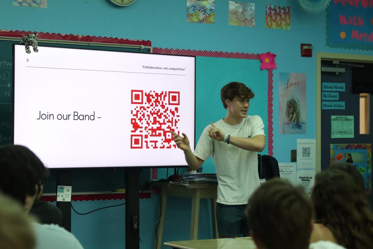 SCAN TO STUDY: Sophomore Jordan Butler gestures to a QR code on screen, encouraging listeners to join the Bowie Study Club. Butler is the founder of the Bowie Study Central website, which is the focus of the club and quickly forming a following.