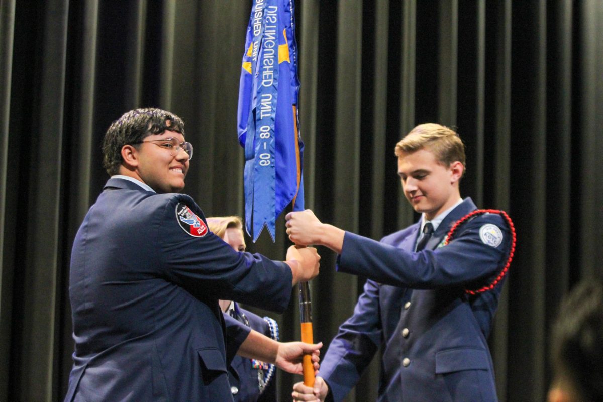 CHANGE OF POWER: Corps commander Cade Sanchez hands the guidon to Will Messerli. The guidon is an important part of the JROTC class, recognizing the unit as a distinguished one. 

