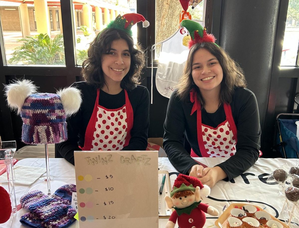 HOLIDAY CHEER: Senior Theresa Linsalata and Gina Linsalata set up shop for the Color Guard's annual winter market. This market raises enough money to support the program for the whole year.
