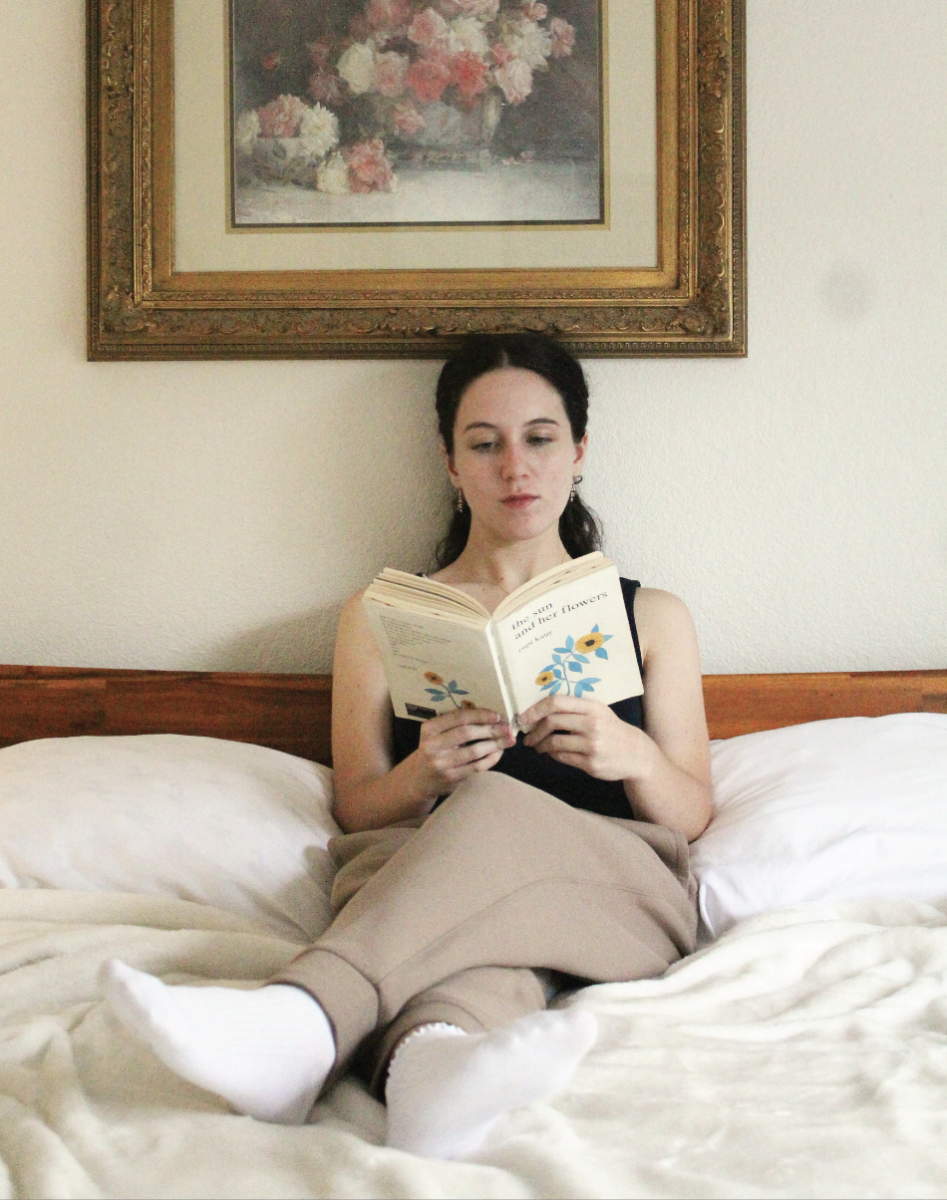 HEALING THROUGH WRITING: Emma Lopez sits reading her own self-published poetry book, “Through the Cracks, We Bloom.” Lopez started writing poetry to help process her feelings and document her mental health journey. 