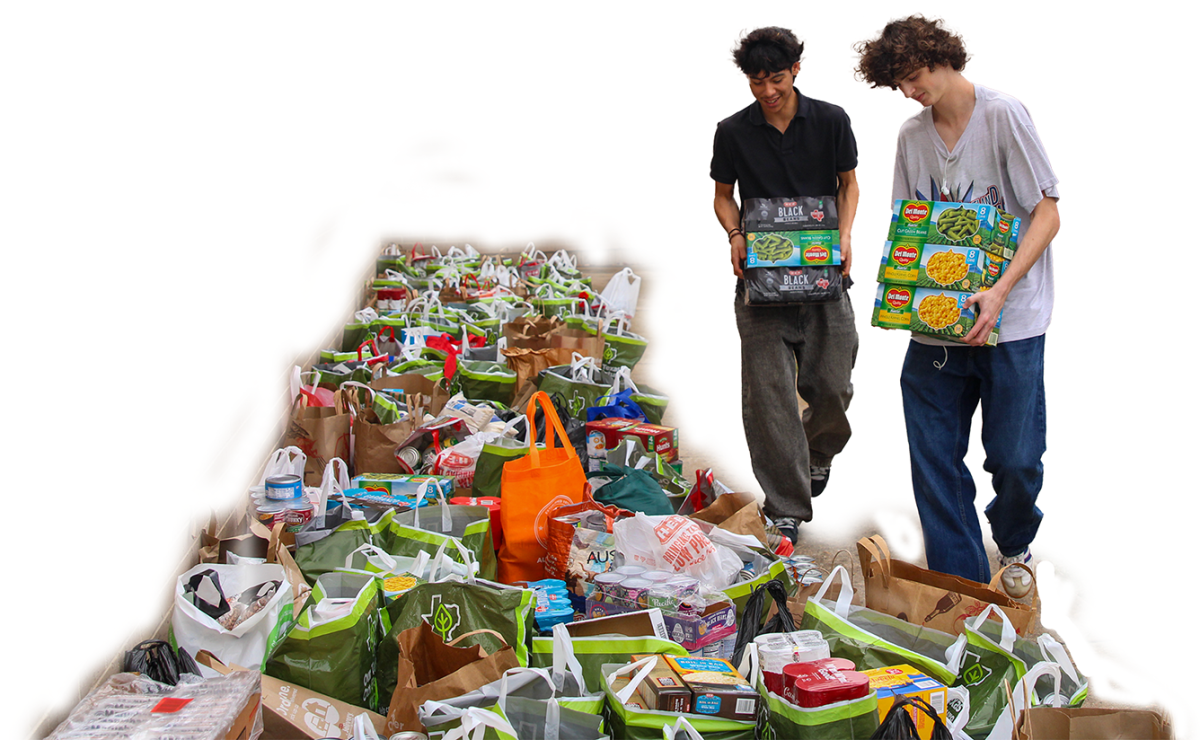 LINING UP THE DONATIONS: Student Council sponsor Alejandro Garcia's students Caleb Galvan and Liam Crowley helped student council members gather all the donated food at the end of the drive to take to the Central Texas Food Bank. Members filled up roughly twelve cars to transport all the donations.