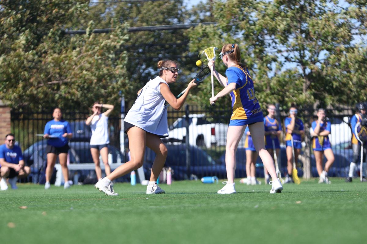 FIGHTING FOR THE BALL: Junior Ella Lovejoy goes into a battle to win the ball against an Anderson Trojan defender. The Bowie Girls Lacrosse team fought hard to the end but came up short.