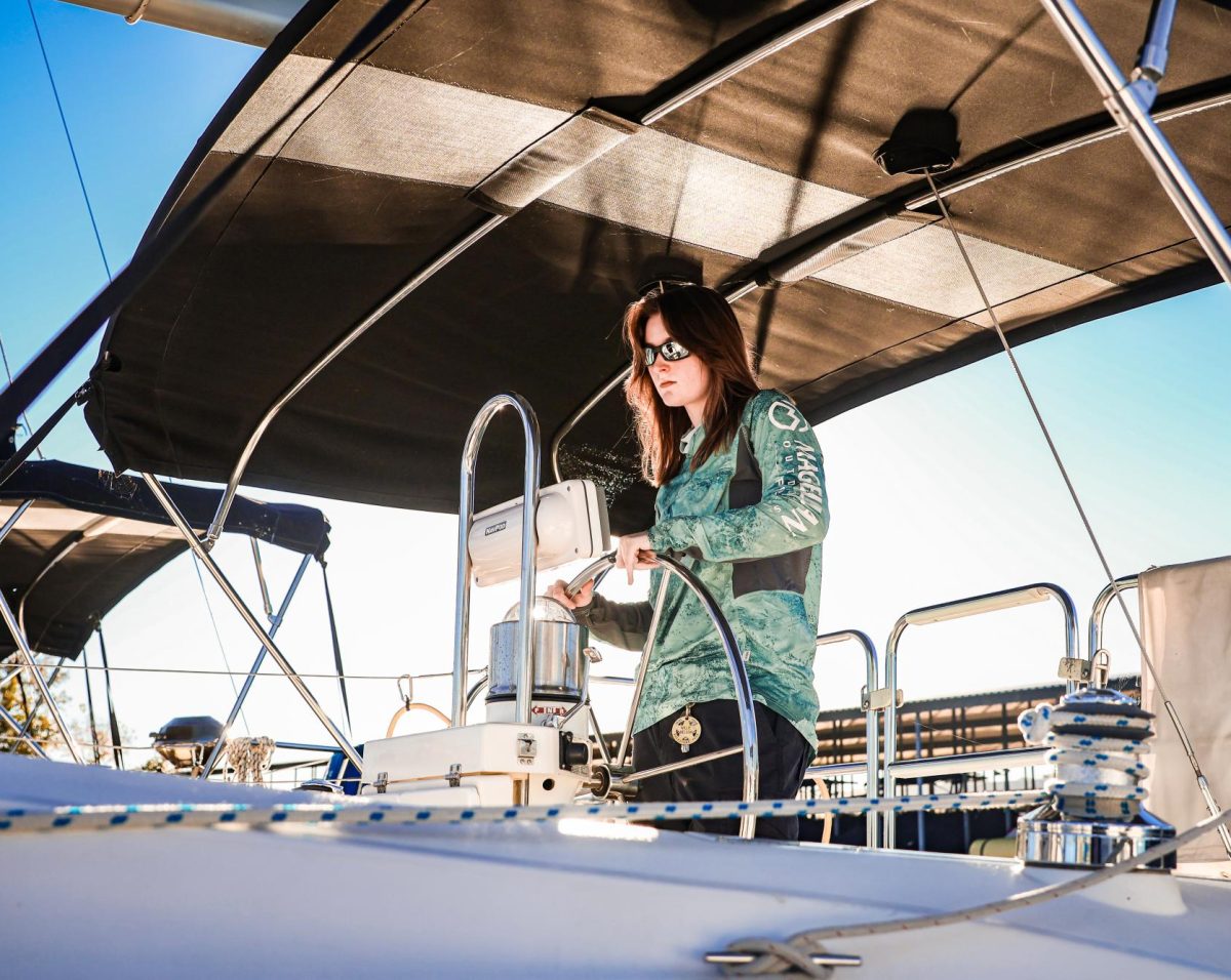 TAKING THE HELM: Corbyn Haley stands at the helm, steering the boat. At 'community sails,' she's able to work as a skipper and crew-member.