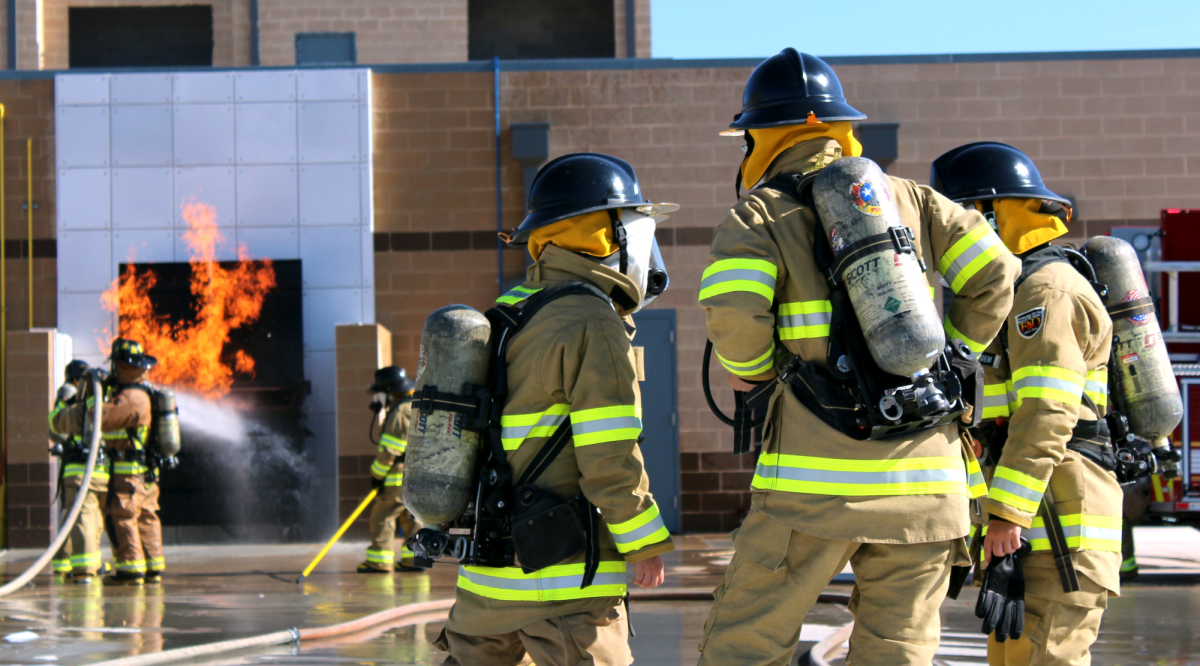 GETTING LIT: A group of Fire II students work together to extinguish a fire on a 'skill day' at the Pflugerville Fire Training Facility. As a member of the LBJ Fire Academy, junior Lucas Geleitsmann has so far learned skills ranging from ladders to rescuing civilians.