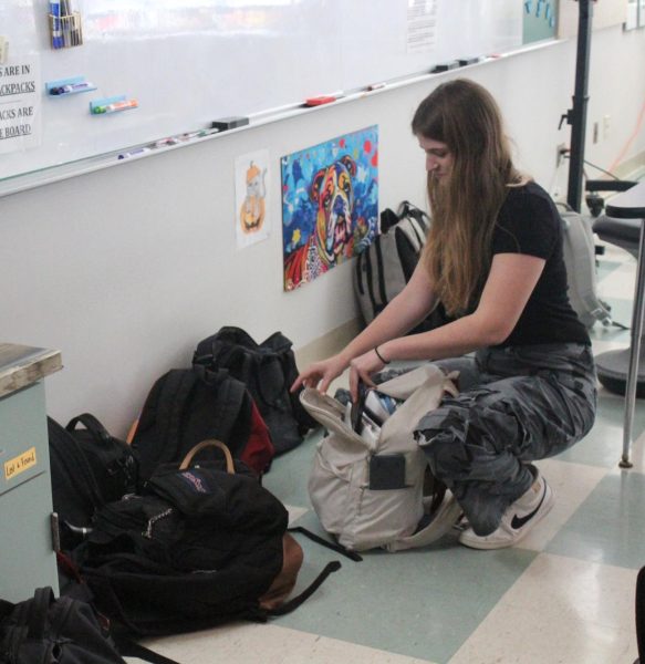 STACKED BAGS: Sophomore Alice Shelton puts her phone in her backpack which is kept at the front of the room. American Sign Language teacher Jessica Bartell has her students keep their bags under her whiteboard to prevent them hiding their phones in class.