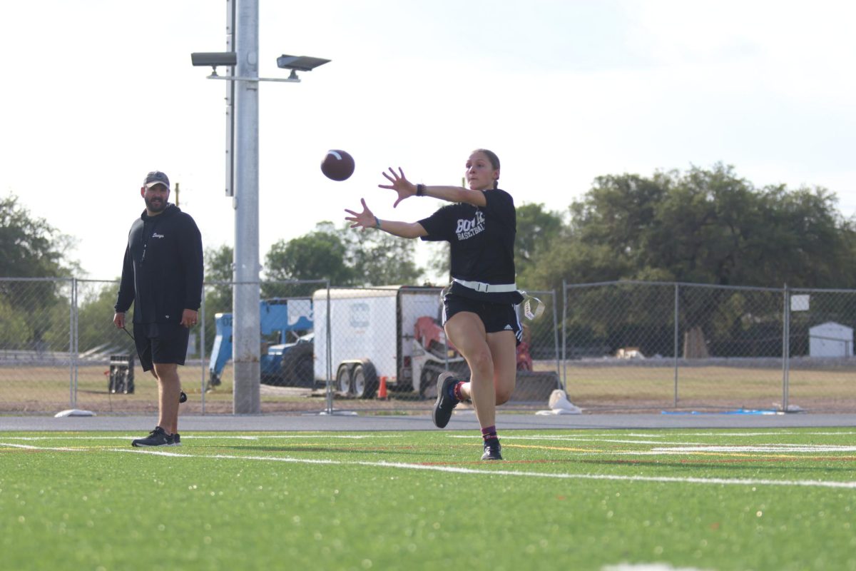 CAUGHT MIDAIR: Senior receiver Peyton Dorsey snags a pass at the 30-yard line. The girls flag football team has just begun their season with a win against Austin High School.