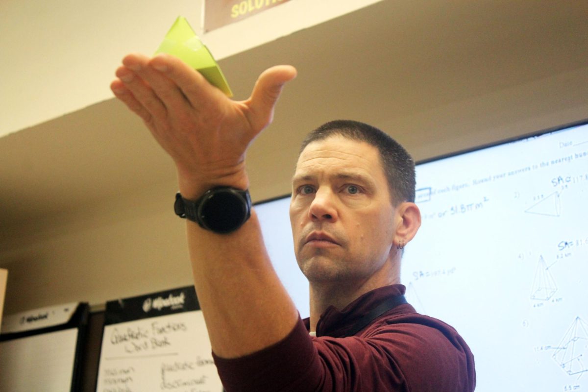 FAMILIAR WITH PYRAMIDS: David Van Newkirk holds pyramid tiles in his hands while demonstrating a geometry activity for his students. He found that students in Ghana were highly motivated to learn and saw education as a privilege, which made them especially focused in the classroom.