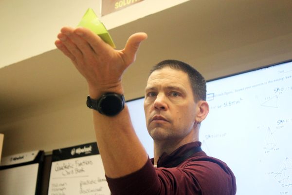 FAMILIAR WITH PYRAMIDS: David Van Newkirk holds pyramid tiles in his hands while demonstrating a geometry activity for his students. He found that students in Ghana were highly motivated to learn and saw education as a privilege, which made them especially focused in the classroom.