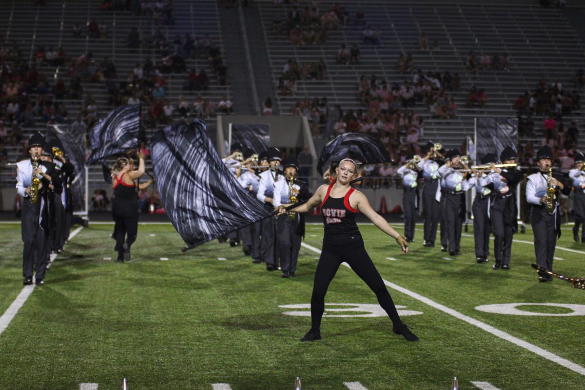 Tossing For Perfection: Senior captain Kaiitlyn Jistell flies her flag. The Color Guard team stays in sync as they prepare for WGI San Antonia regional finals.